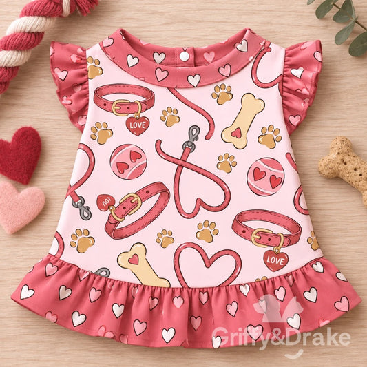 Love Unleashed ruffle pet shirt with a pink dog-themed print and dark pink heart-patterned sleeves and hem.