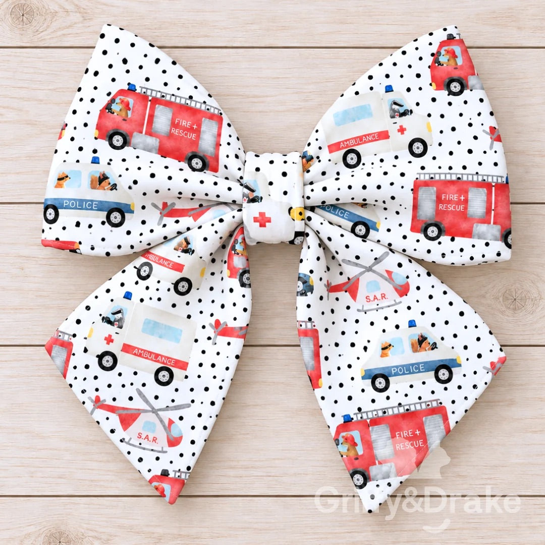 Ready to Rescue pet sailor bow featuring fire trucks, ambulances, police vehicles and rescue helicopters on a white dotted background.